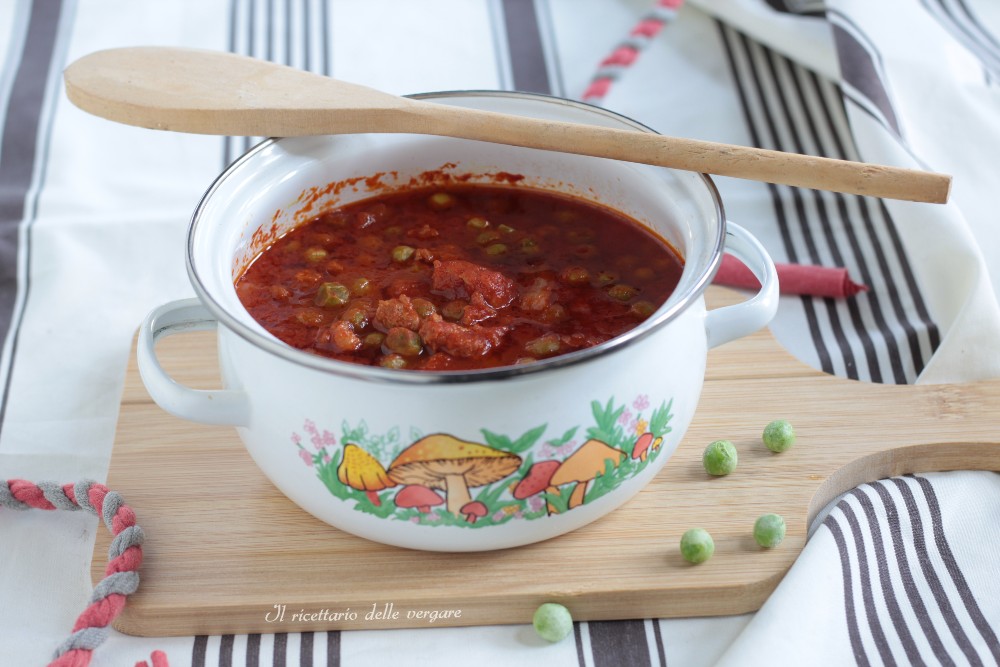 Broken-up sausage and peas in a ceramic saucepan during cooking.
