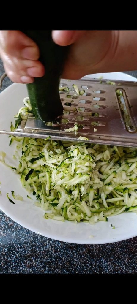 Reiben Sie die Zucchini
