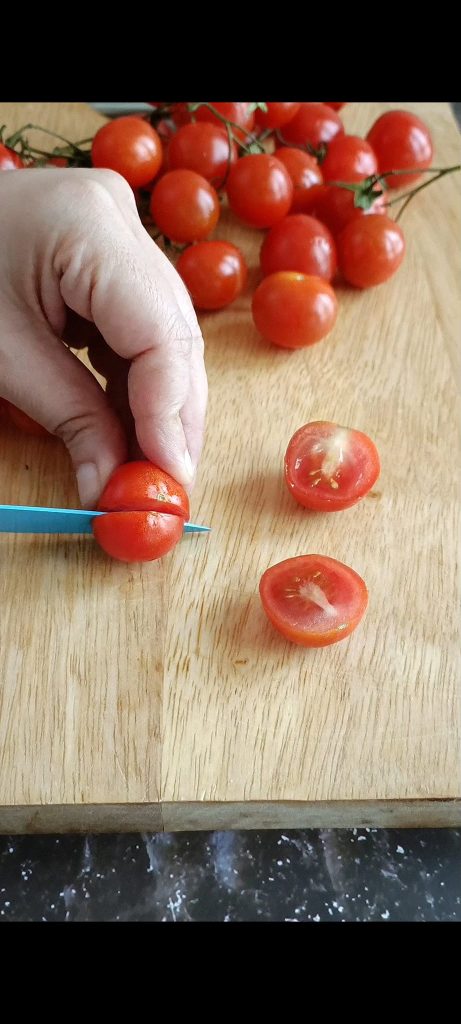 Wir schneiden Kirschtomaten in zwei Hälften