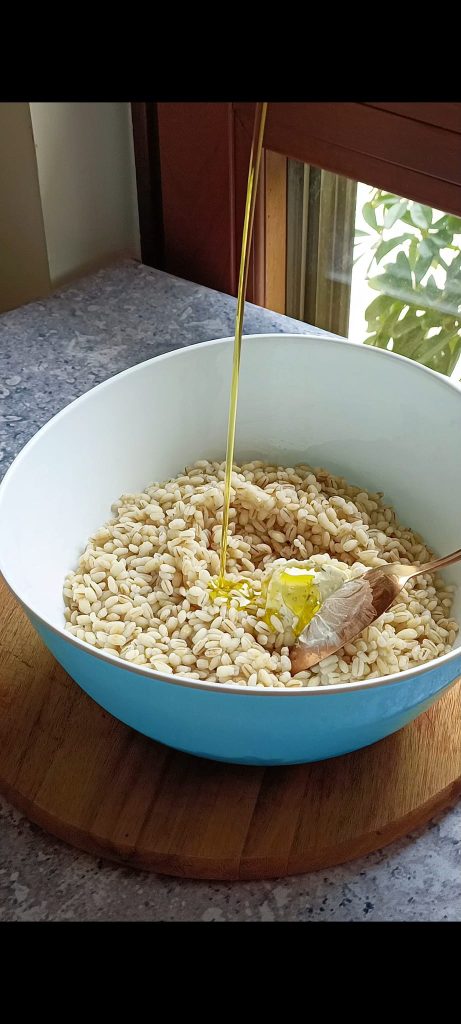 Wir würzen die Gerste mit Öl und Frischkäse