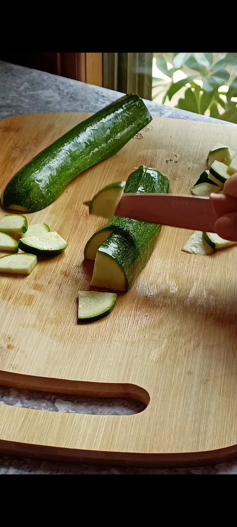 Wir schneiden die Zucchini in Würfel und die Zwiebeln in Scheiben