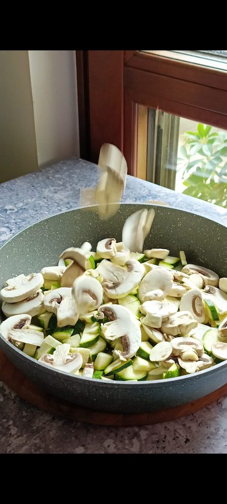 Wir fügen Zucchini, Pilze und Petersilie hinzu