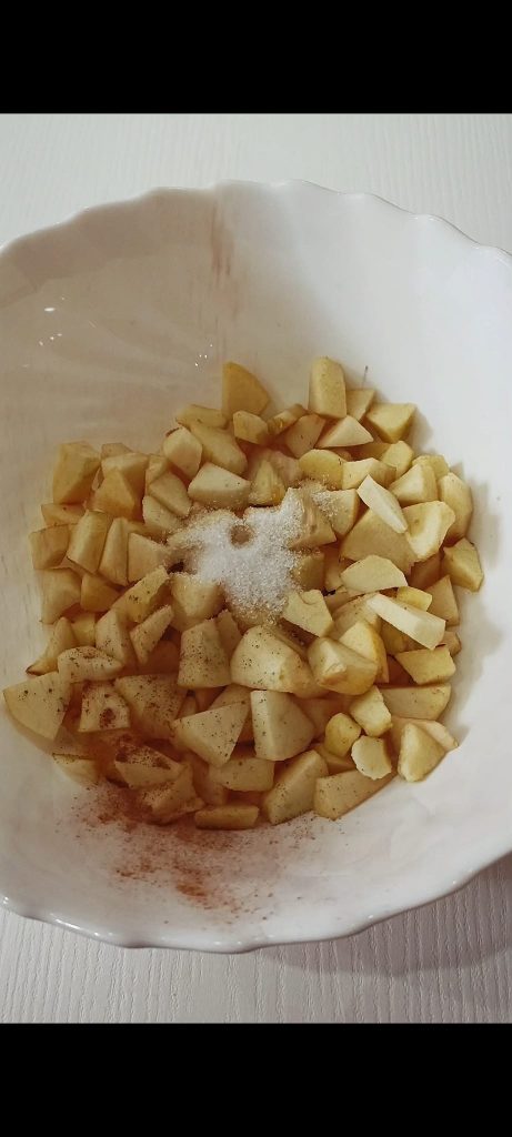 Fügen Sie Zucker und Zimt zu den Äpfeln hinzu