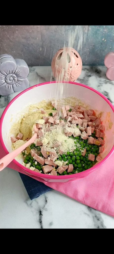 Wir fügen Erbsen, Mortadella und geriebenen Parmesan hinzu