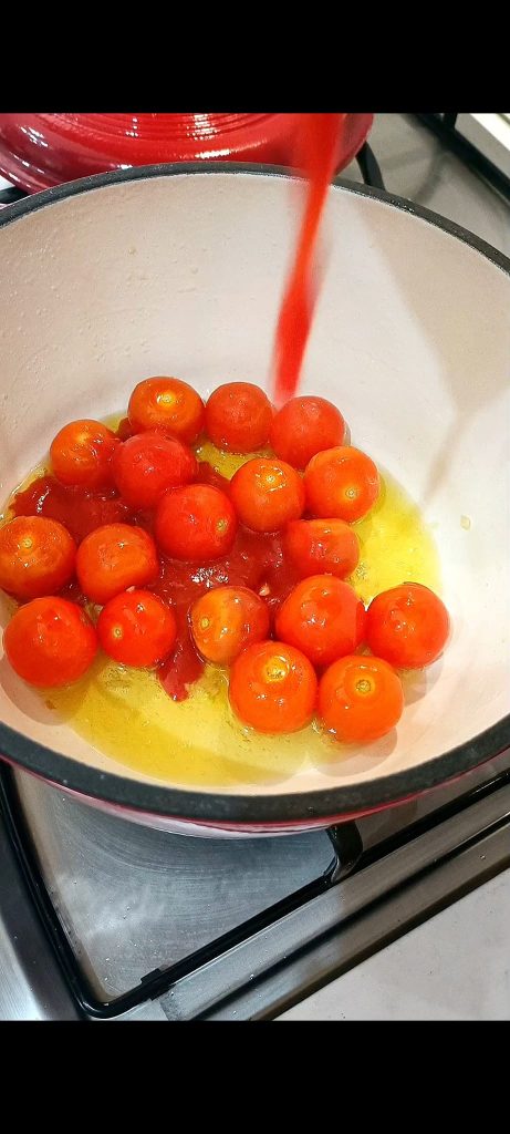 Kirschtomaten im Topf mit Öl und Knoblauch