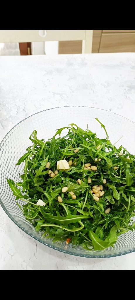 Rucola, Pinienkerne, Knoblauch, Öl und Salz