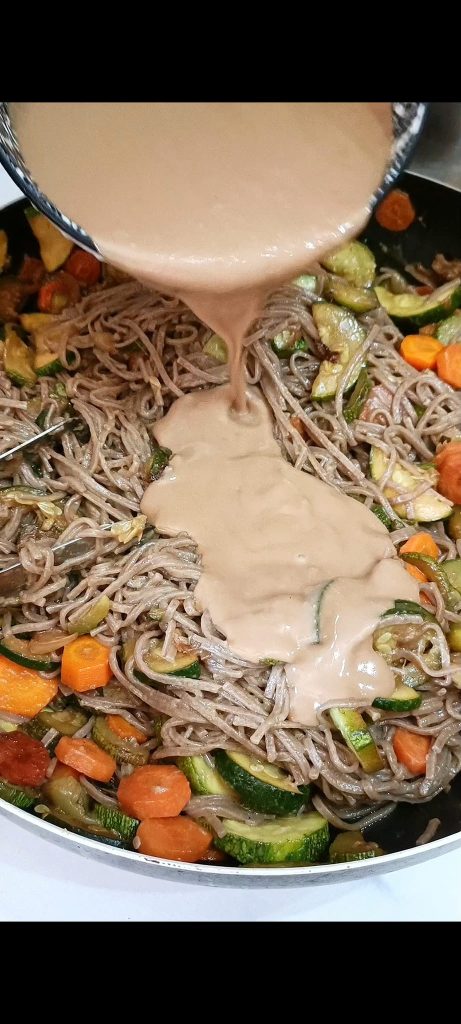Wir würzen die Soba-Nudeln mit der Sauce und dem Gemüse