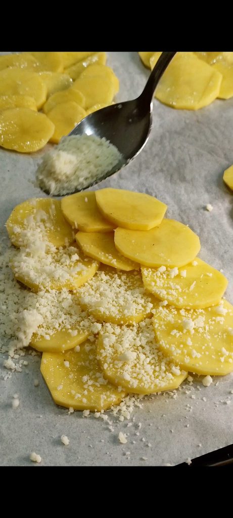 Wir bestreichen die Kartoffeln mit Öl und geriebenem Käse