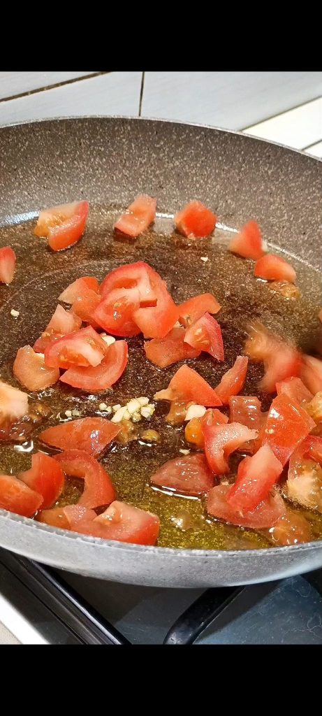 Tomaten in der Pfanne mit Öl und Knoblauch