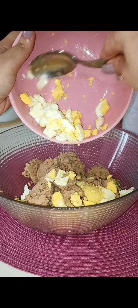 Wir fügen hartgekochte Eier, ein rohes Ei und Pecorino hinzu