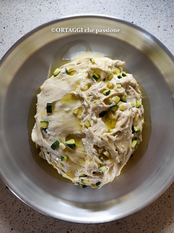 Öl auch auf den Teig der Focaccia mit Zucchini und Zwiebeln gießen