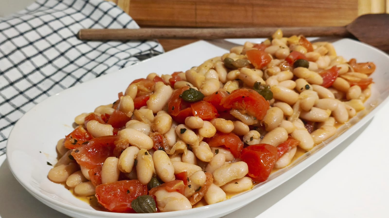 Würzige Bohnen mit Tomaten und Kapern: das einfache und köstliche mediterrane Rezept