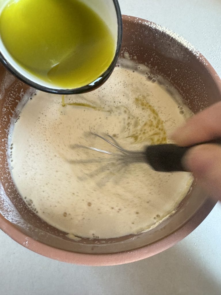 Hinzufügen von der Hälfte des Öls zur traditionellen toskanischen Cecina-Mischung