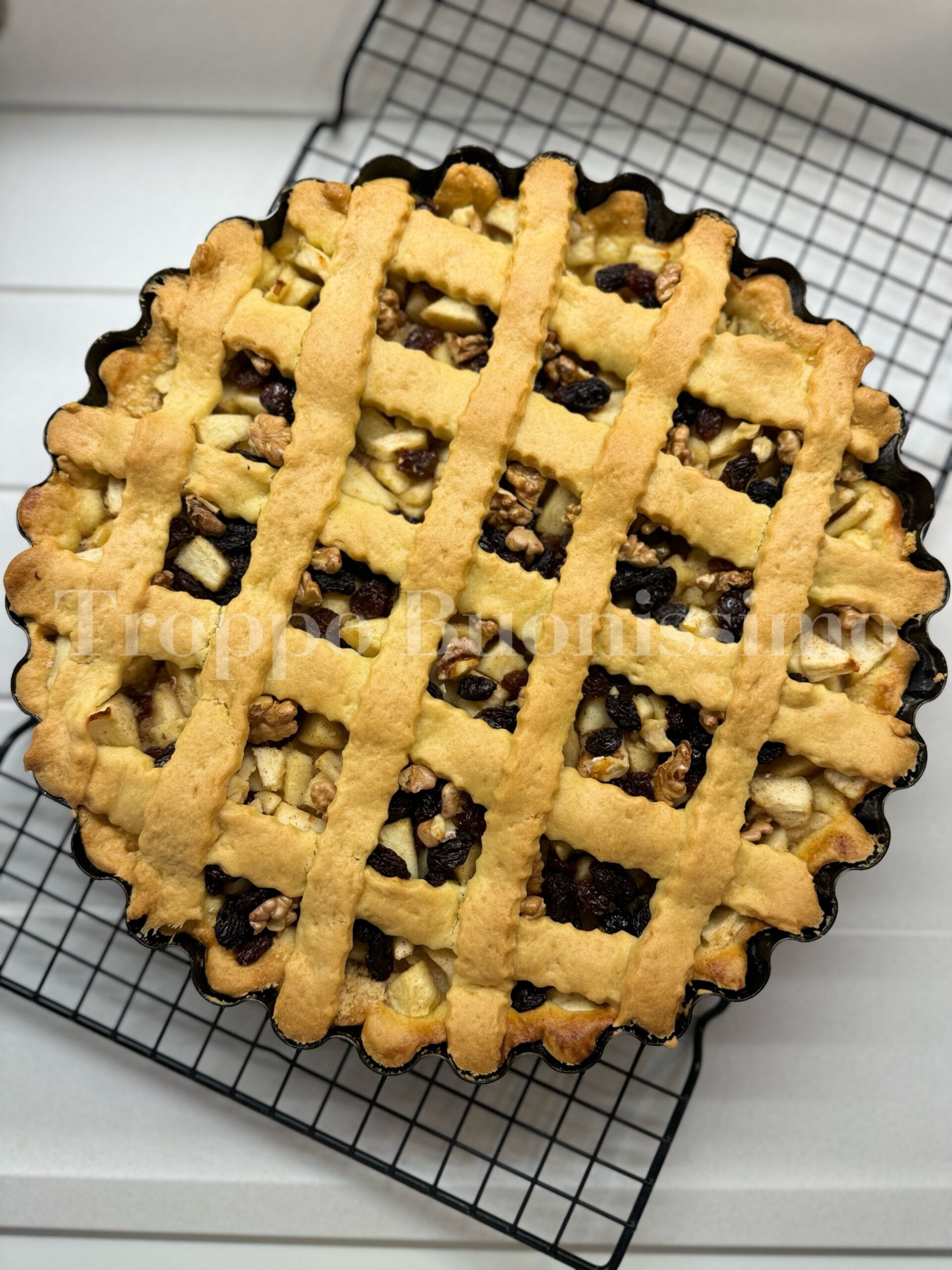 Gedeckter Apfelkuchen mit Zimt, Rosinen und Walnüssen