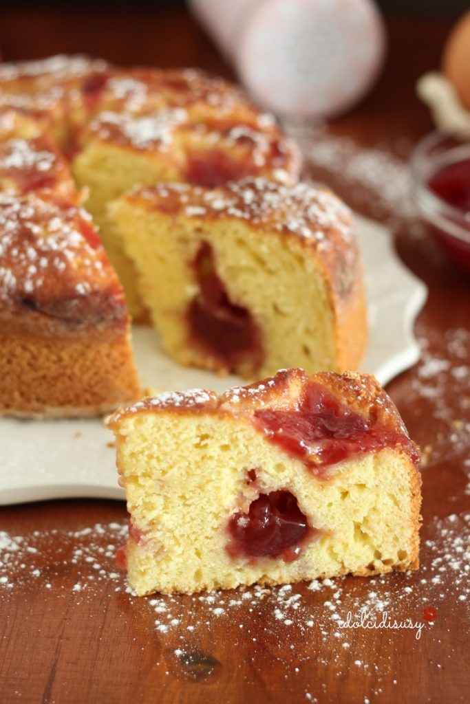 Ein Stück weiche Ricotta- und Marmeladentorte mit roter Fruchtmarmelade, ideal für Frühstück oder Snack