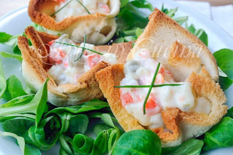 Gefüllte Körbchen mit russischem Salat und Toastbrot