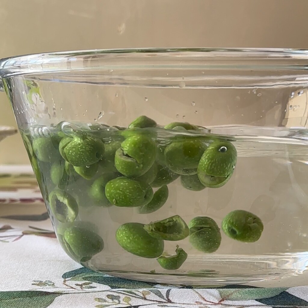 zerdrückte grüne Oliven in Wasser, um sie zu süßen