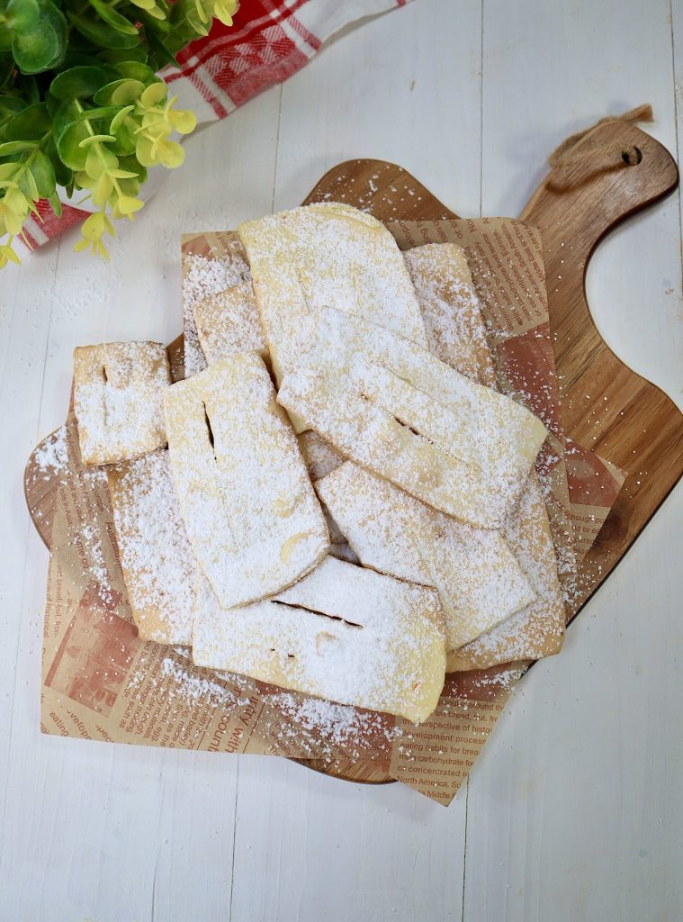 Die Chiacchiere in der Heißluftfritteuse sind leicht, lecker und sehr einfach zuzubereiten. Mit meinen Tricks werden sie auch mit dieser Kochmethode perfekt. Für die Zubereitung benötigt man nur wenige Zutaten: Mehl, ein Ei, Zucker, Likör (Strega, Grappa oder was Sie bevorzugen), Backpulver und Orangenschale: sie werden noch duftender, aber auf Wunsch können Sie diese auch weglassen. Der Teig ist wirklich sehr einfach. Sie können ihn von Hand mit einem Nudelholz ausrollen oder mit der Pastamaschine: in diesem Fall empfehle ich eine sehr dünne Dicke, 1 oder maximal 2, wenn Sie sie dicker mögen. Alternativ zur Heißluftfritteuse finden Sie unten alle Anweisungen für die Zubereitung im Ofen oder in der Pfanne mit dem klassischen Frittieren. Denken Sie daran, dass sie im Ofen oder in der Heißluftfritteuse nie identisch mit den frittierten sein werden, da der klassische fettige Geschmack fehlt, ich werde Ihnen hier keine Unwahrheiten erzählen. Aber sie werden sicherlich sehr köstlich, knusprig und viel leichter sein.