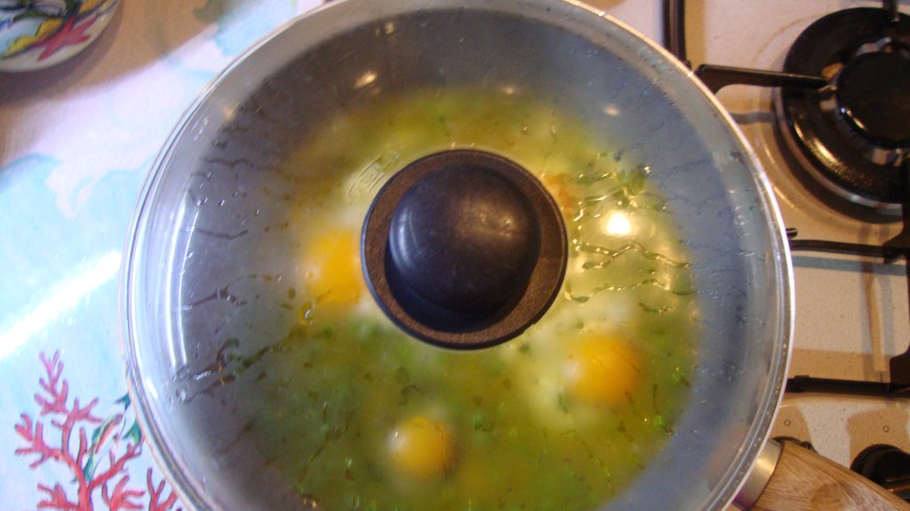 Eier mit Erbsen in der Pfanne geschmort