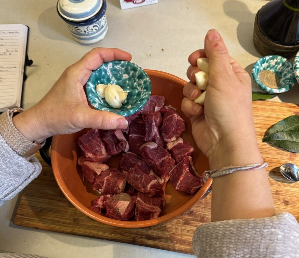 Knoblauch zum einfachen toskanischen Peposo aus dem Ofen hinzufügen