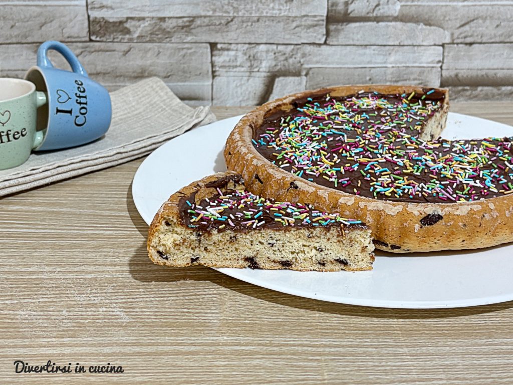 Im klugen Kuchenform gebackene Torte, gefüllt mit einer Schicht Nutella und dekoriert mit bunten Zuckerstreuseln.