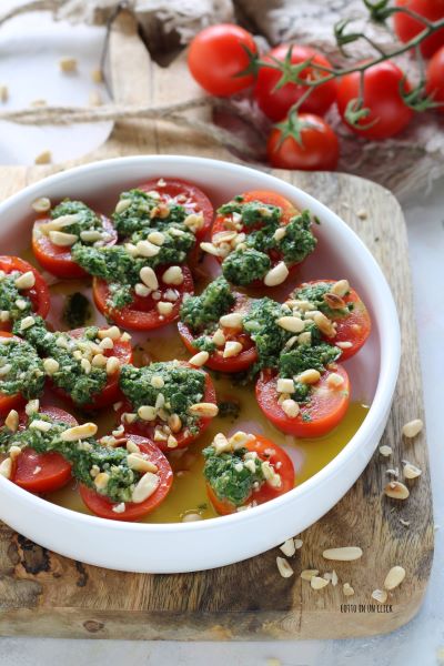Kirschtomaten zurücknehmen, gehackte Pinienkerne verteilen und servieren