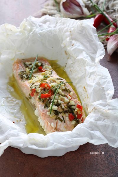 Entfernen Sie das Garn und servieren Sie den Lachs im Pergament direkt nach dem Backen im Ofen