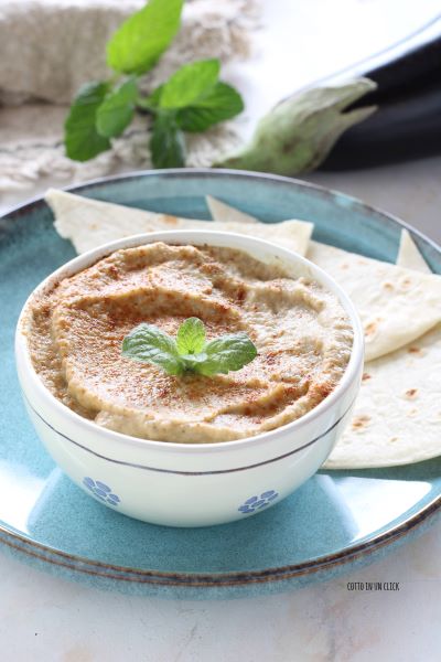 Geben Sie den Babaganoush in eine kleine Schüssel, fügen Sie eine Prise Paprika hinzu, dekorieren Sie mit einigen Minzblättern und servieren Sie