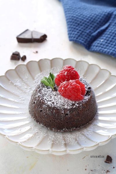 Oberfläche mit Puderzucker bestäuben und mit Himbeeren und Minzblättern dekorieren