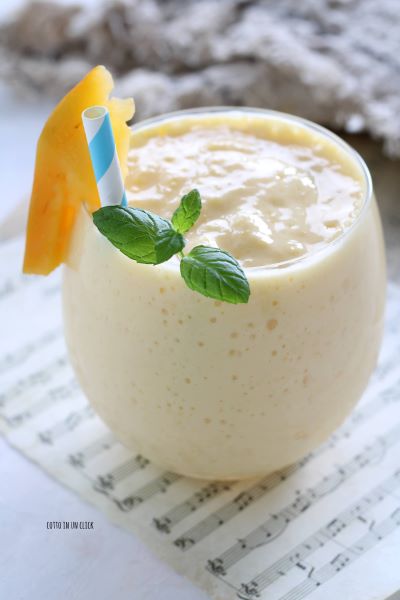 serviert das Mango-Lassi mit Minzblättchen
