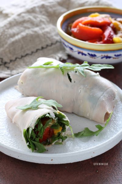 serviert die Rollen mit einigen Rucola-Blättern