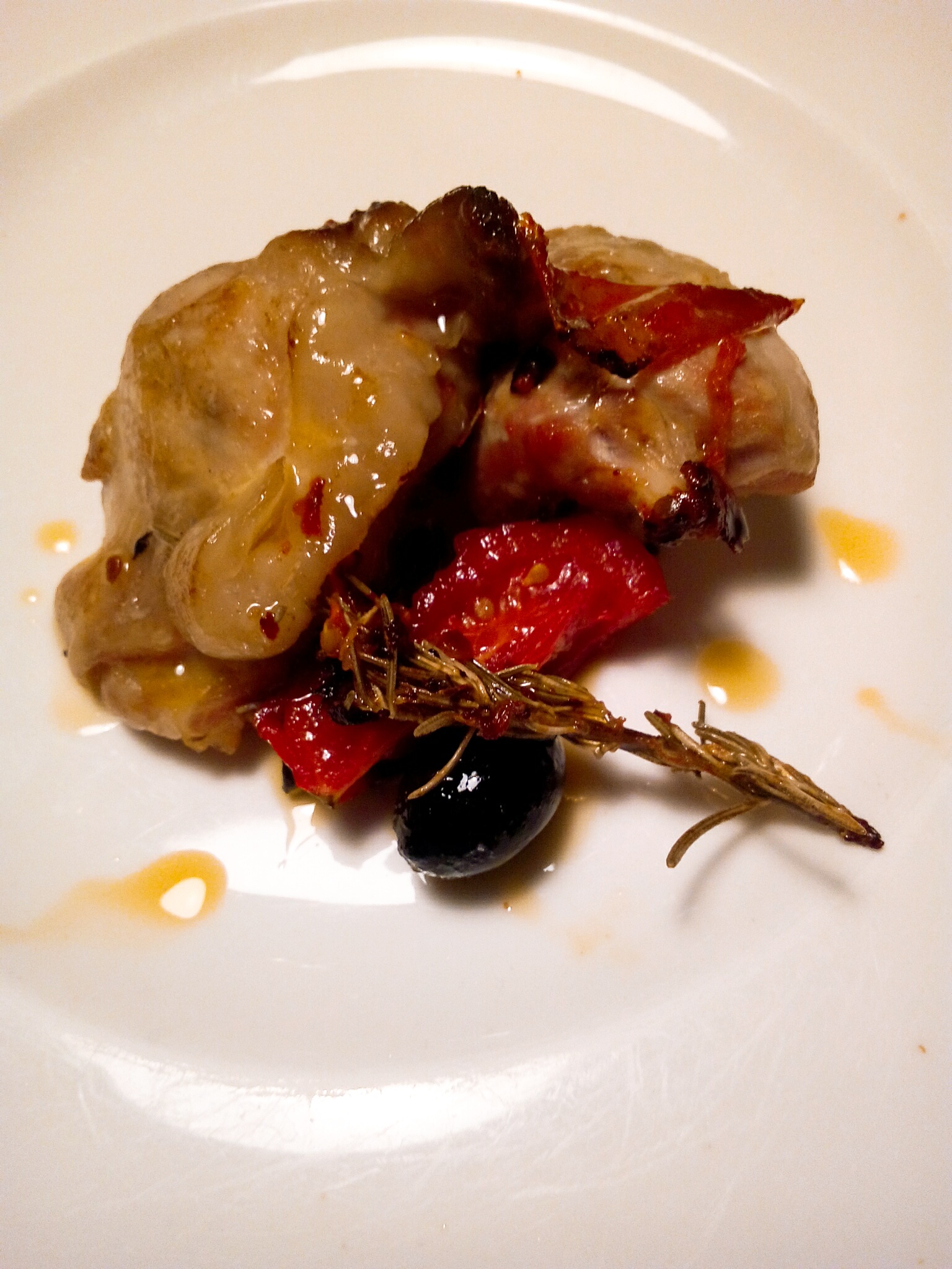 Kaninchen mit frischen Kirschtomaten und schwarzen Oliven in der Pfanne