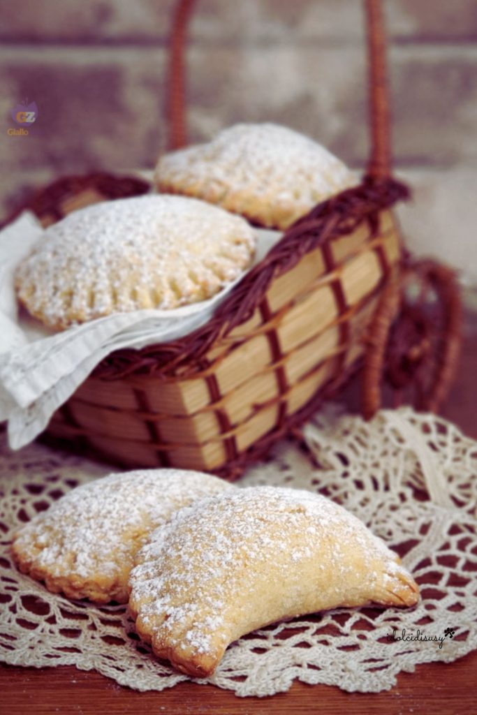 Halbmondförmige, im Ofen gebackene und mit Puderzucker bestäubte San-Giuseppe-Ravioli, serviert auf einer Serviette mit Korb