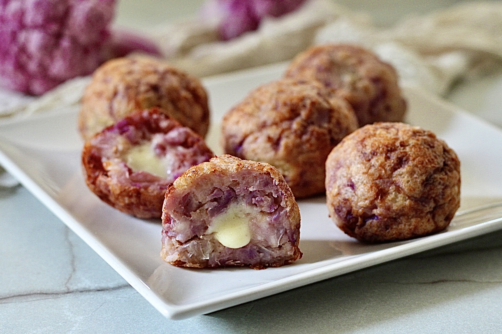 Lila Blumenkohl- und Kartoffelklößchen mit cremigem Kern im Heißluftfritteuse.