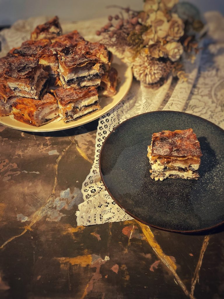 Stück Prekmurska Gibanica mit 8 sichtbaren Schichten aus Mohn, Quark, Nüssen und Äpfeln