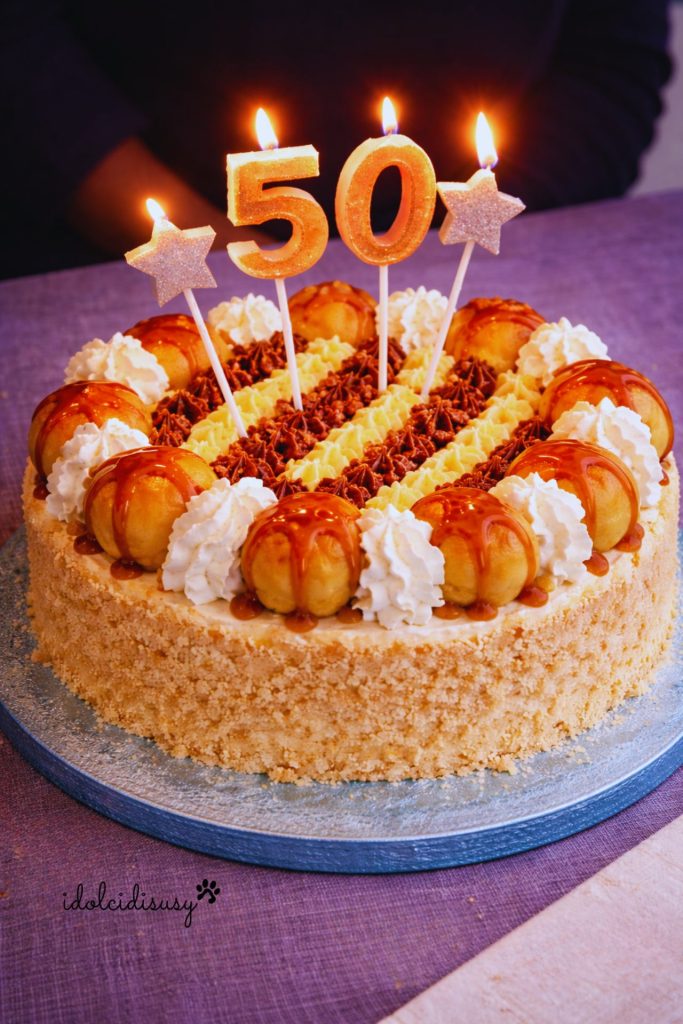 Hausgemachte Saint Honoré Torte mit karamellisierten Profiteroles, Schlagsahnehäubchen, Vanillecreme und Schokoladencreme, dekoriert für einen Geburtstag