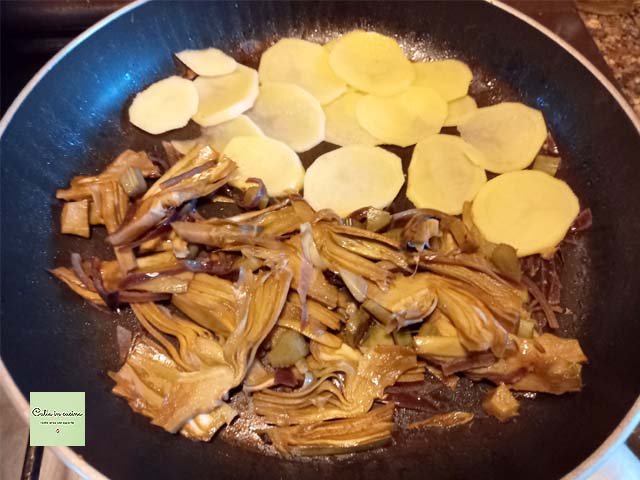 Artischocken und Kartoffeln in der Pfanne kochen
