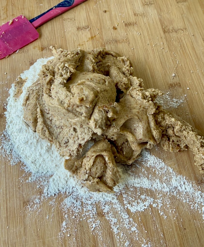 Teig für zuckerfreie Kekse mit Rosinen und Mandeln auf der Arbeitsfläche