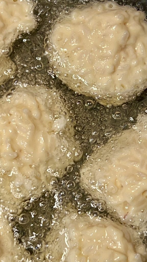 Toskanische Reiskrapfen, die im heißen Öl frittiert werden