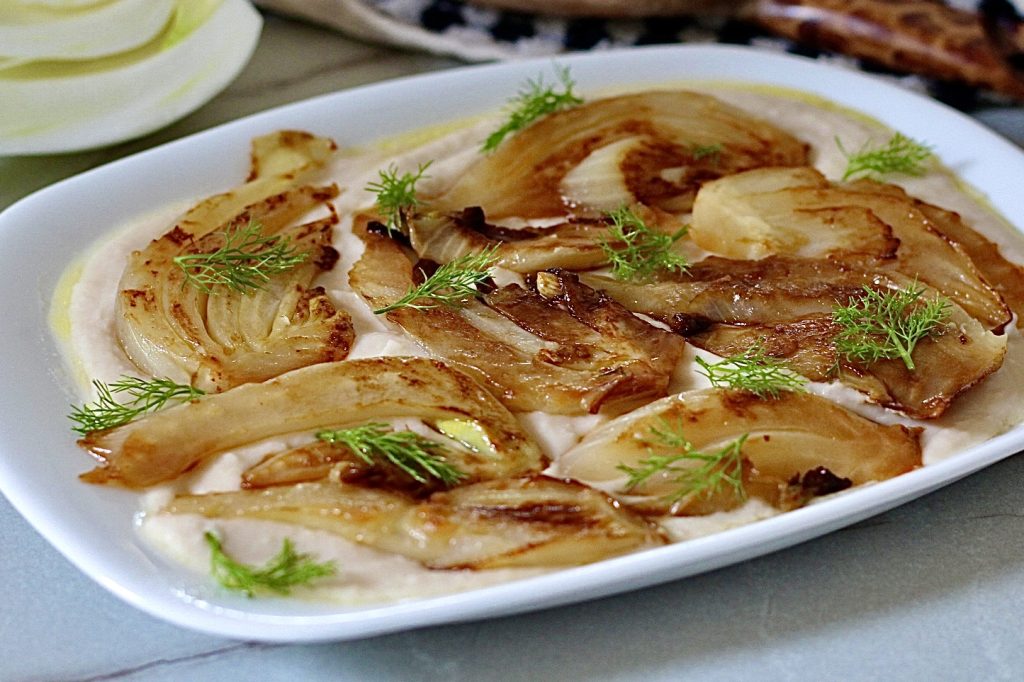 In der Pfanne gebratener Fenchel auf einem Bett aus Cannellini-Bohnen-Creme