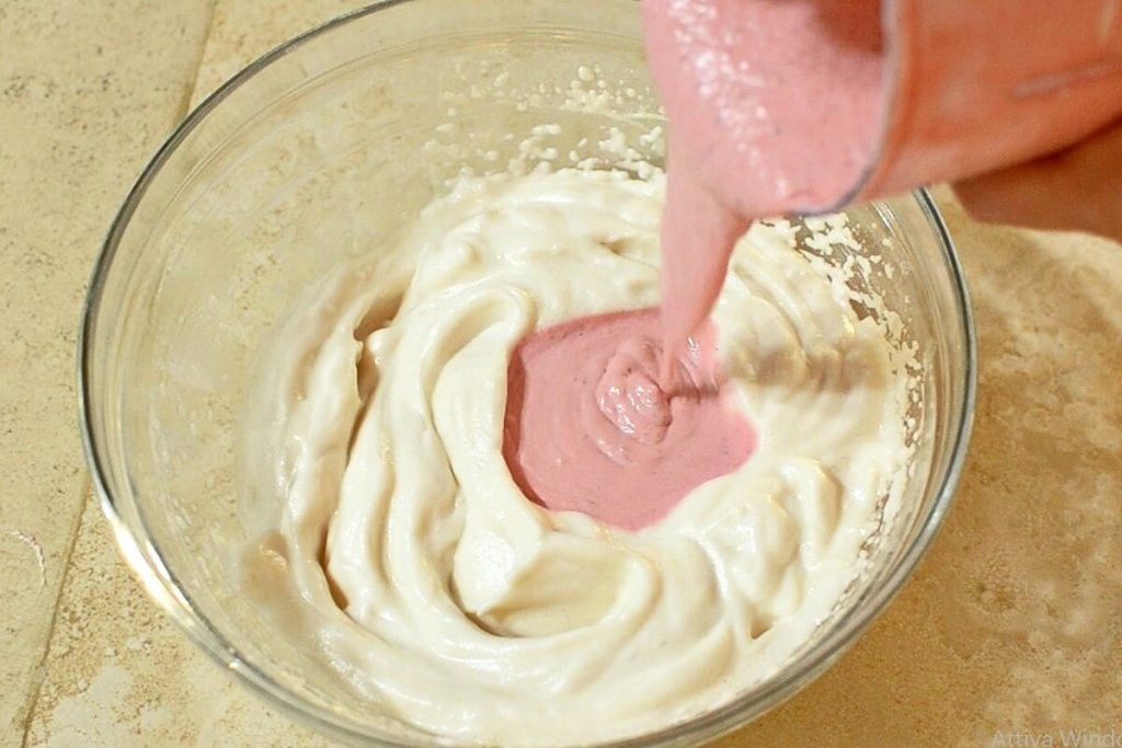 Zugabe von pürierten Erdbeeren und Mascarpone zum geschlagenen Eiweiß