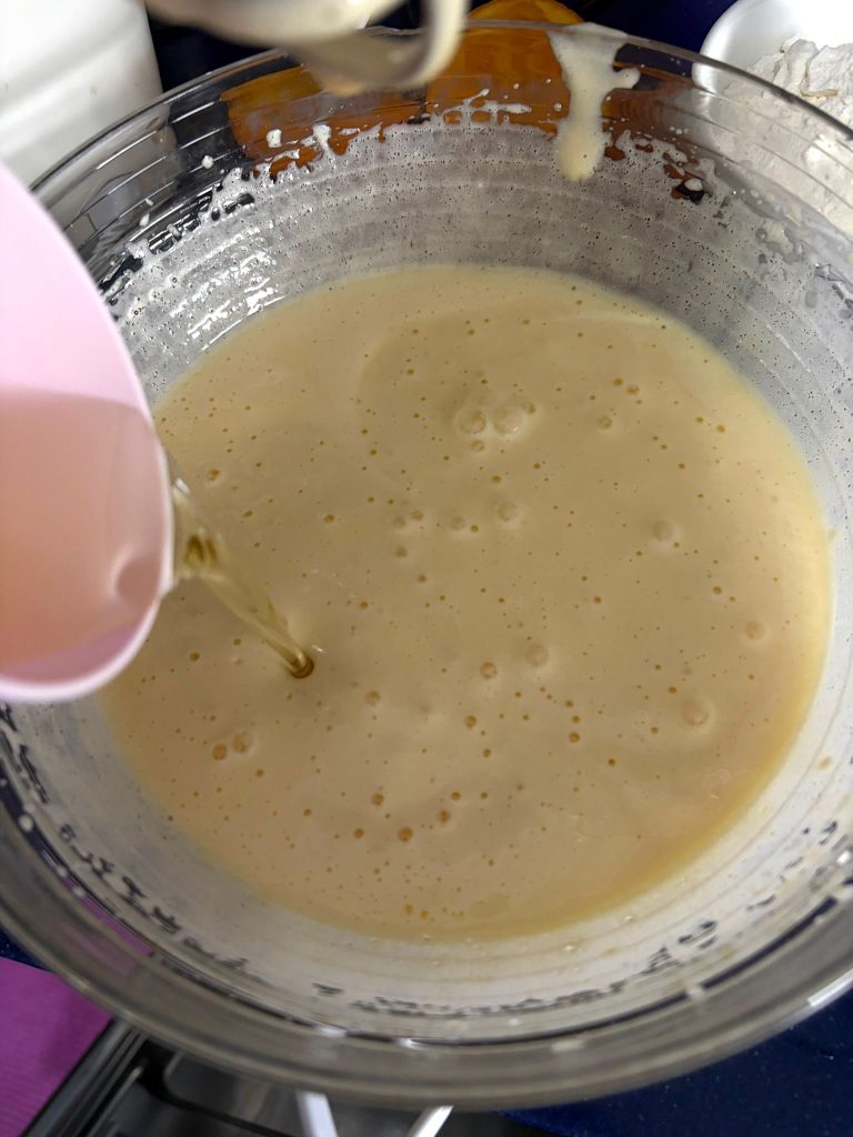 Sonnenblumenöl wird in den Teig für den Ricotta-Orangen-Gugelhupf gegossen