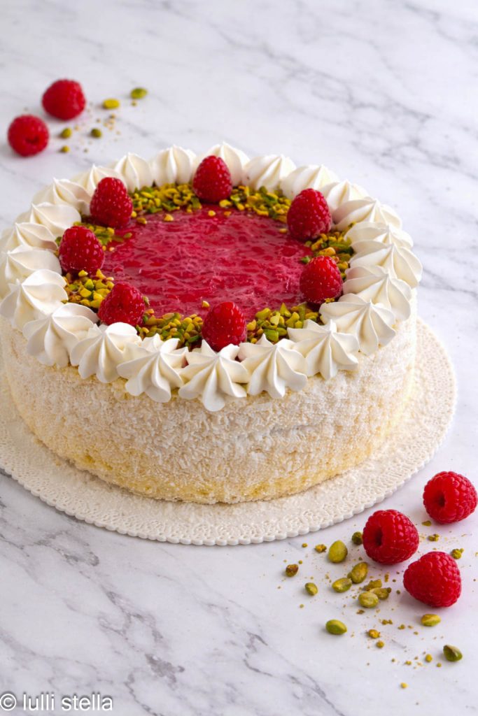 Karibik-Torte fertig mit Kokos-Chibouste und Himbeergelee auf weißem Teller, Frontansicht”