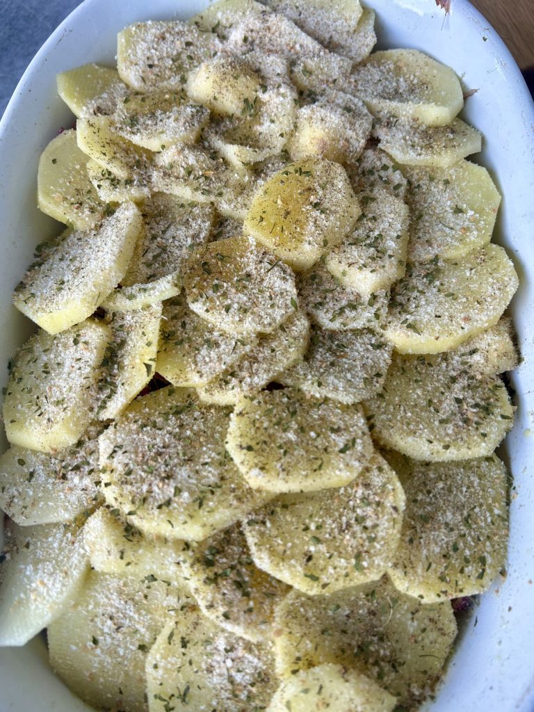 letzte Schicht Kartoffeln in der Auflaufform vor dem Backen