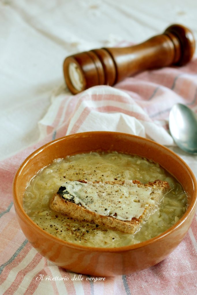Überbackene Borettanen-Zwiebelsuppe in einer Terrakottaschale mit Crostini und Pfeffer.
