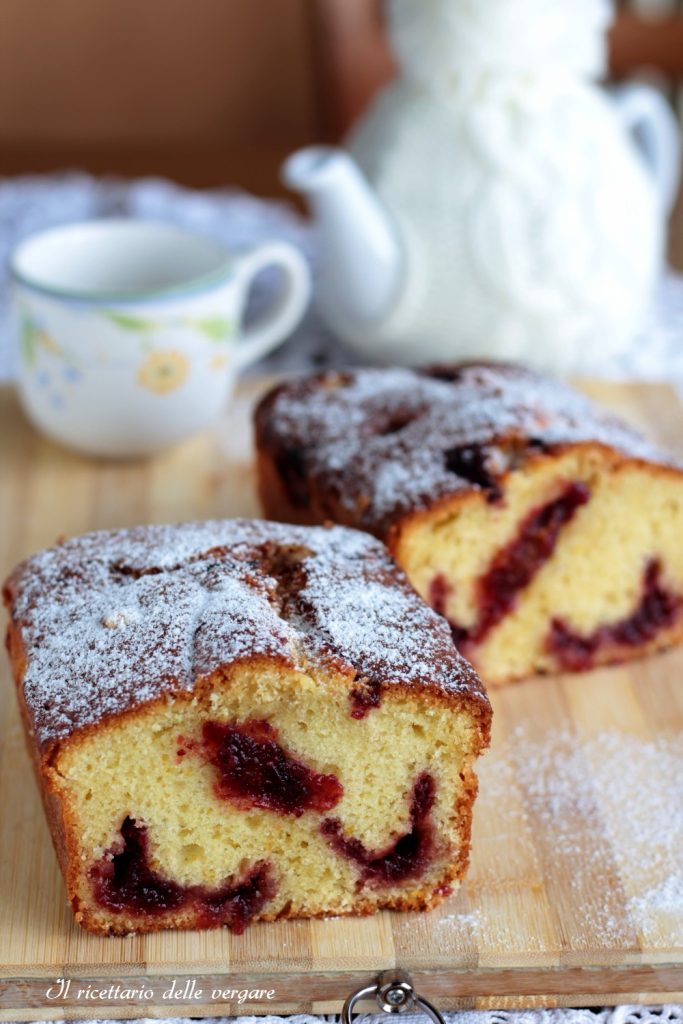 Nahaufnahme einer Scheibe Wolken-Plumcake mit Marmeladenherz und Puderzucker
