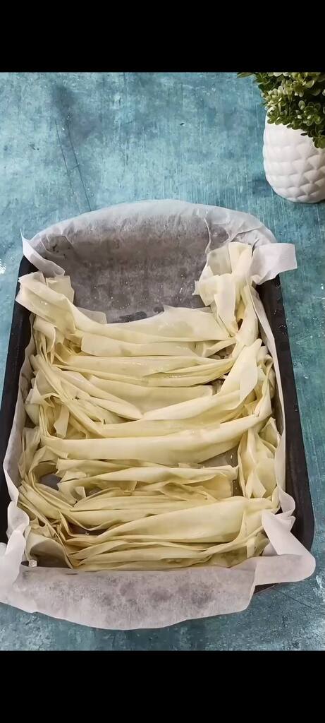 Disposons les feuilles de pâte filo beurrées dans le moule