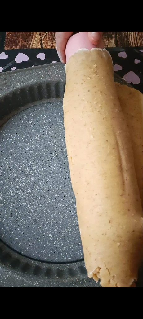 Chemisez avec la pâte sablée aux noix le moule à tarte