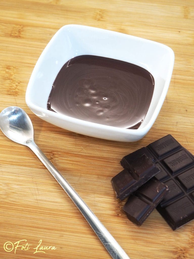 chocolat fondu et cubes de chocolat solides sur une planche en bois