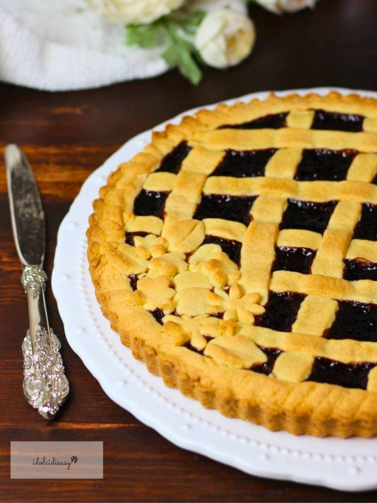 Détail de la tarte à la confiture faite maison avec un tressage de pâte brisée et de la confiture foncée.